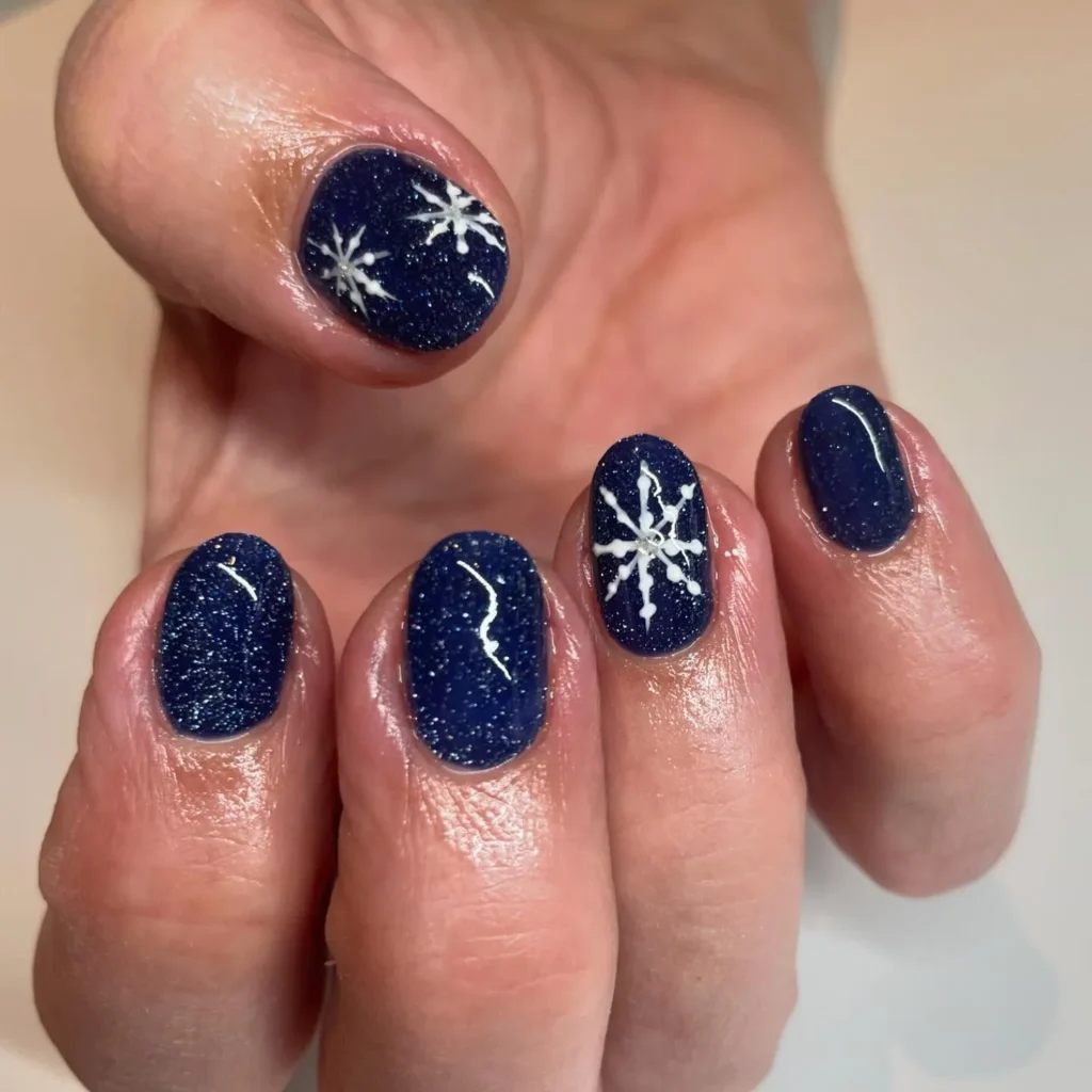 navy shimmer christmas almond nails with snowflake detail