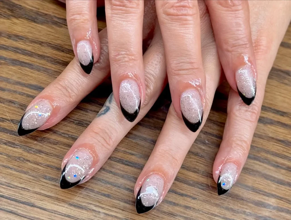 black French tip almond nails outlined in silver glitter