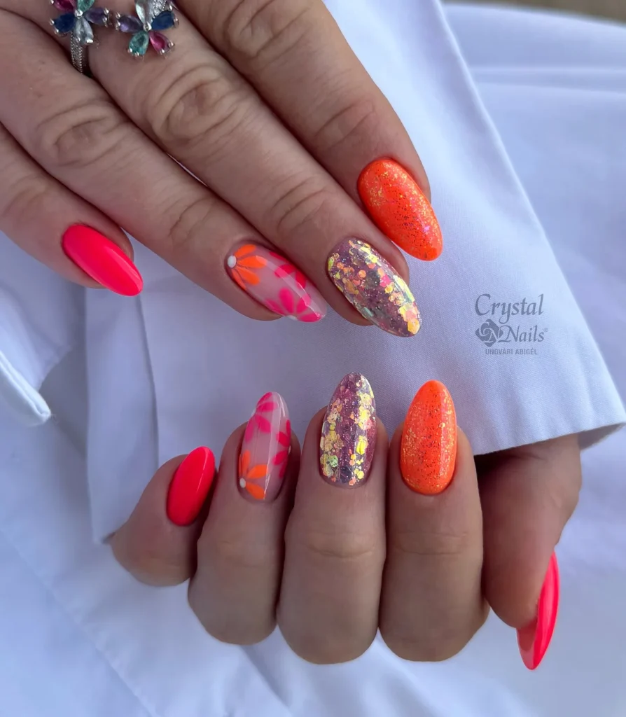 solid orange almond nails topped with gold glitter