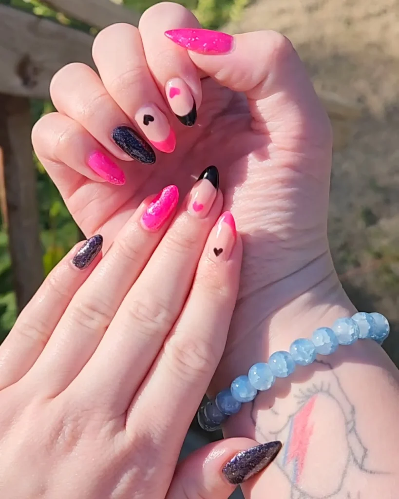 hot pink long almond nails with black glitter heart accents