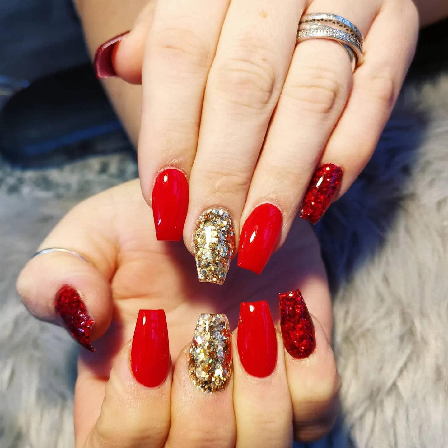Red nails with gold glitter accents