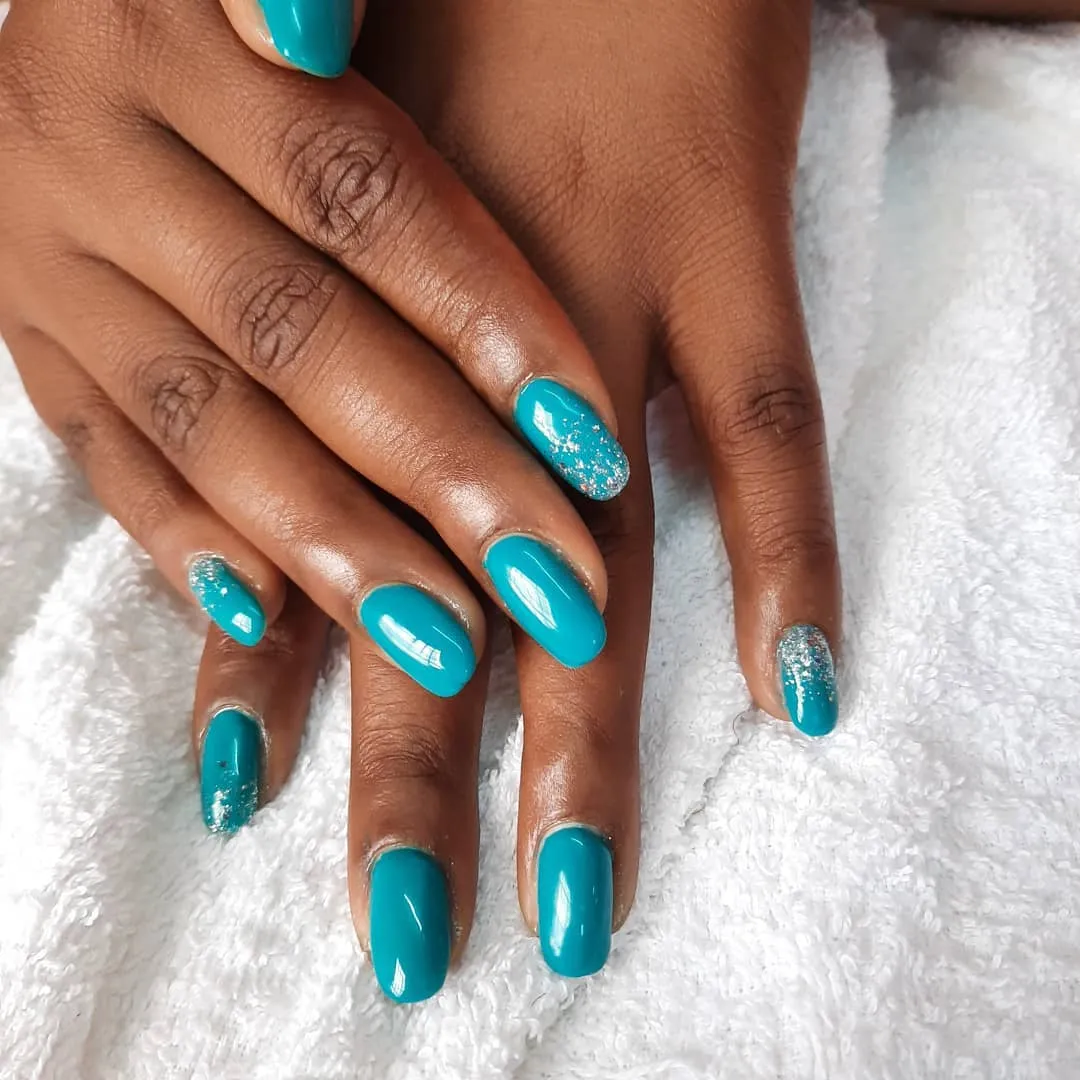 Bright turquoise blue summer nails with silver glitter accents