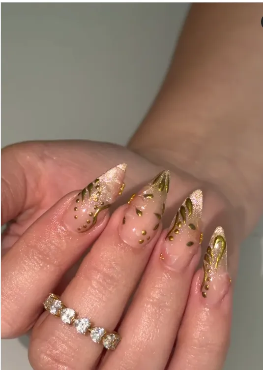 gold hand-painted botanical vine art on sheer glitter long almond nails