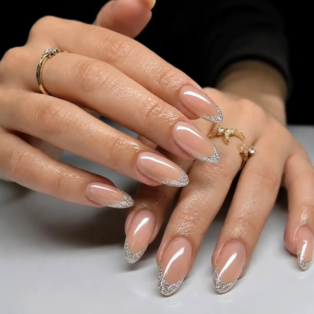 nude almond nails with a silver glitter French tip