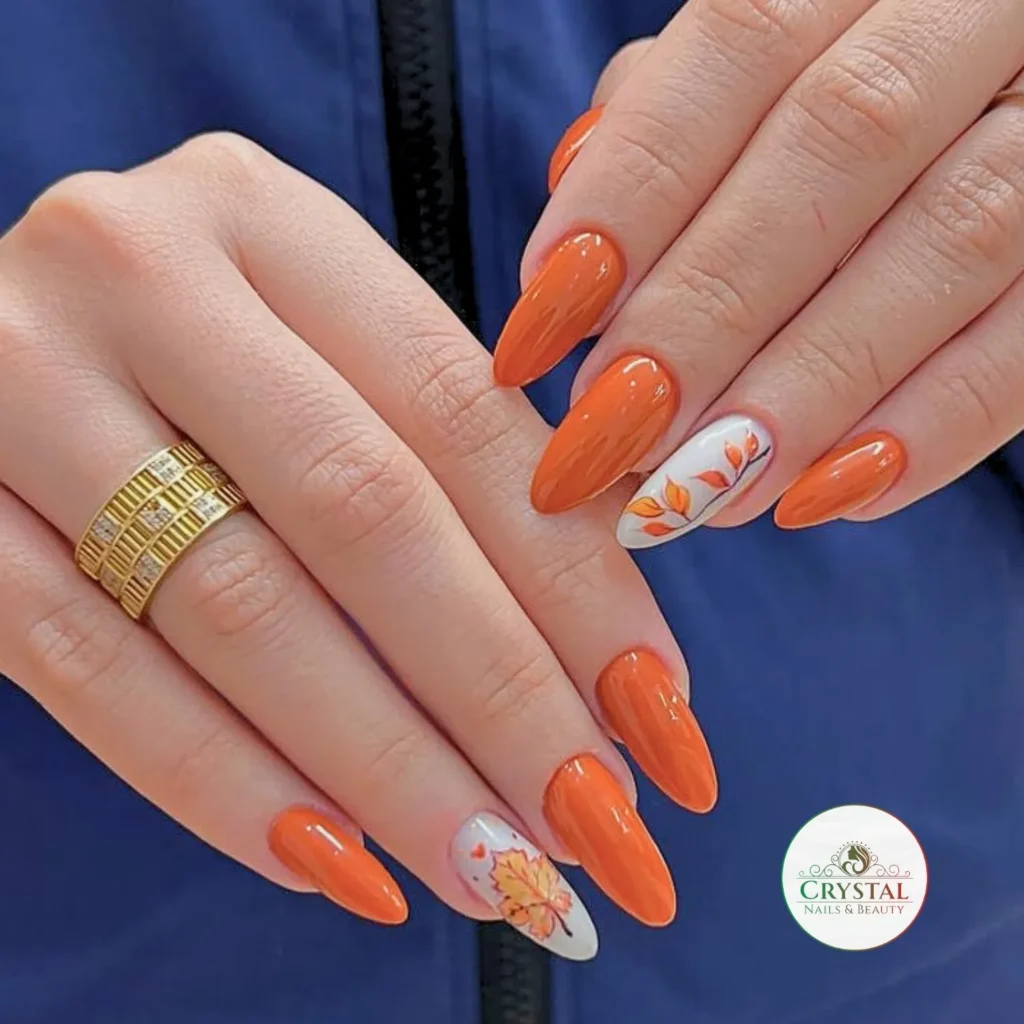 burnt orange tone on almond nails with a hand-painted autumn leaf accent nail