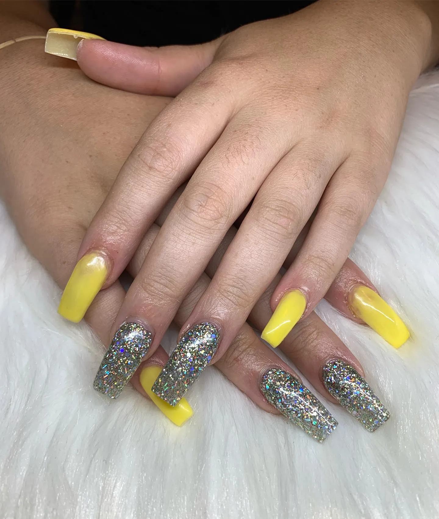 Glossy buttercup yellow coffin nails with a silver holographic glitter accent nail