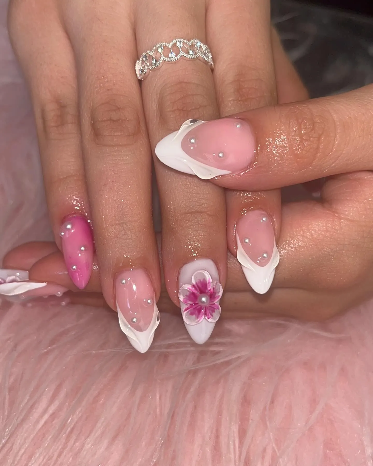 Pink French tip nails with white tips, a pink flower and a hot pink accent nail