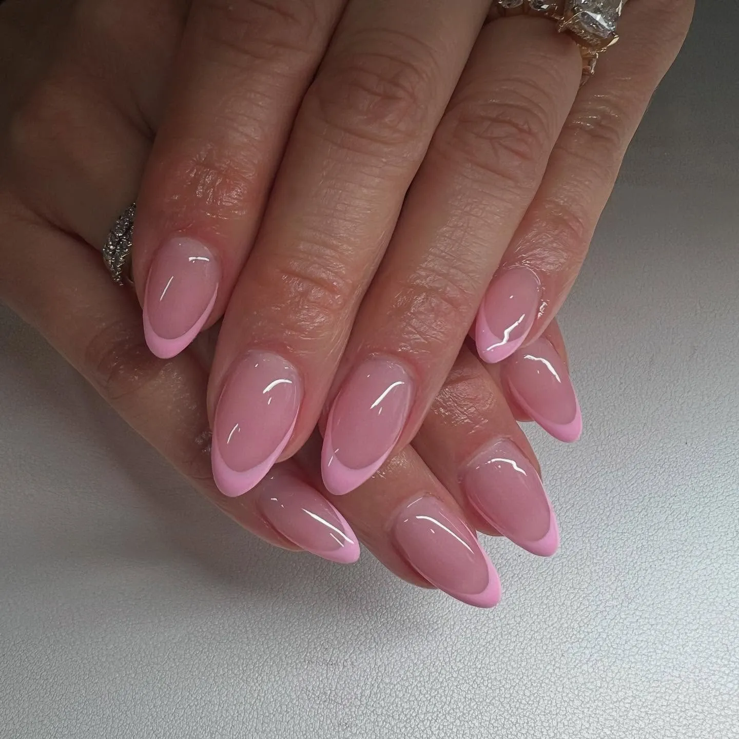 Pink French tips on glossy almond nails