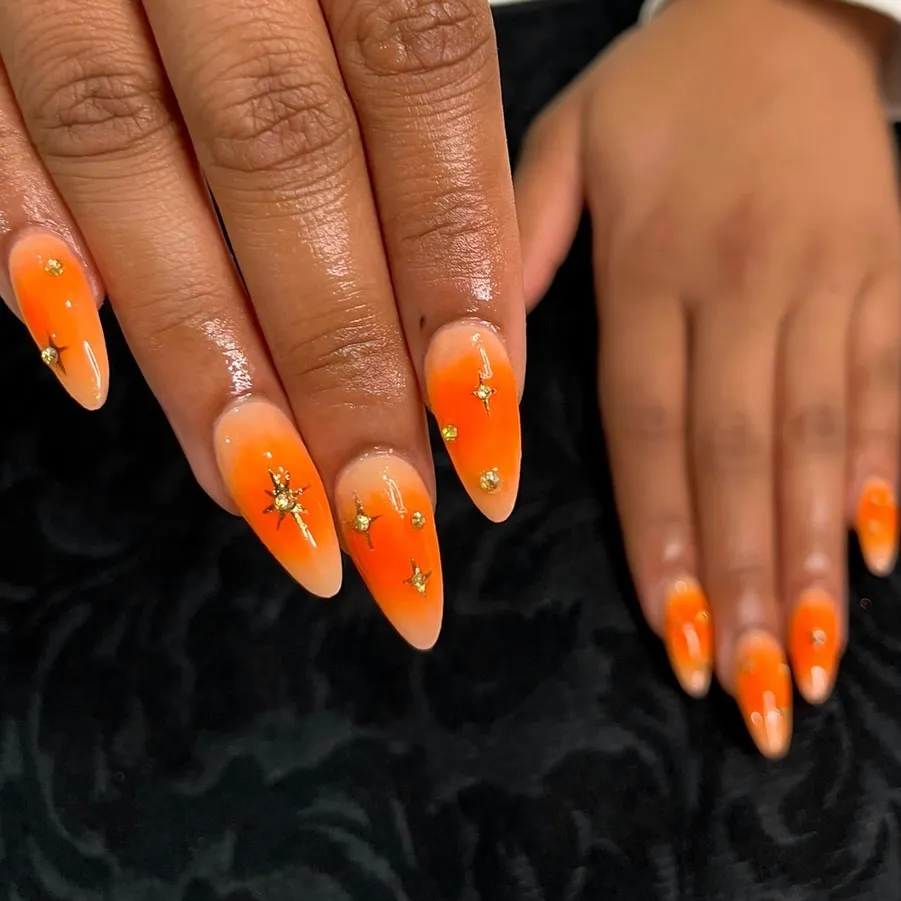 orange aura nail art with gold celestial gem accents on almond nails