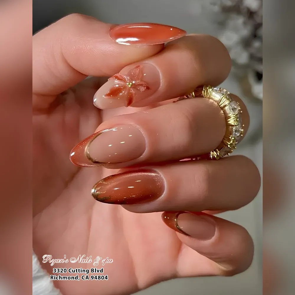 copper cat-eye chrome almond nails with a 3D burnt-orange flower and gold linework