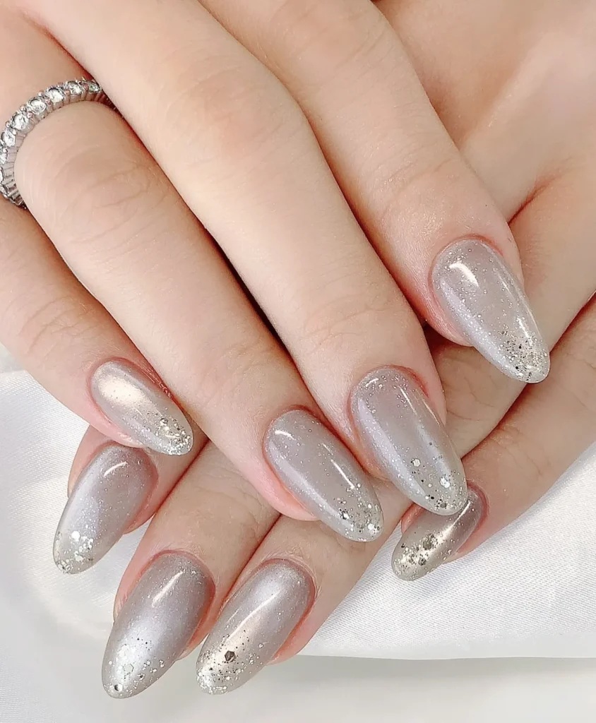 gray shimmer almond nails with gold glitter tips