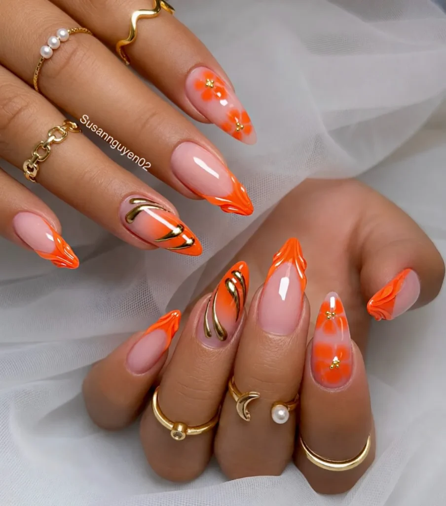 orange floral French tip almond nails paired with hand-painted gold flame linework