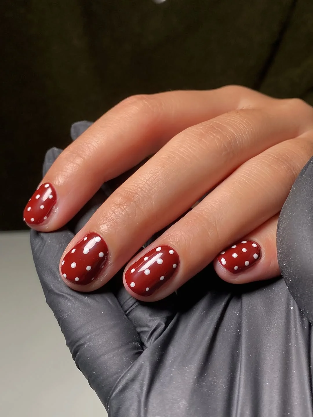 Short red nails with white polka dot accents