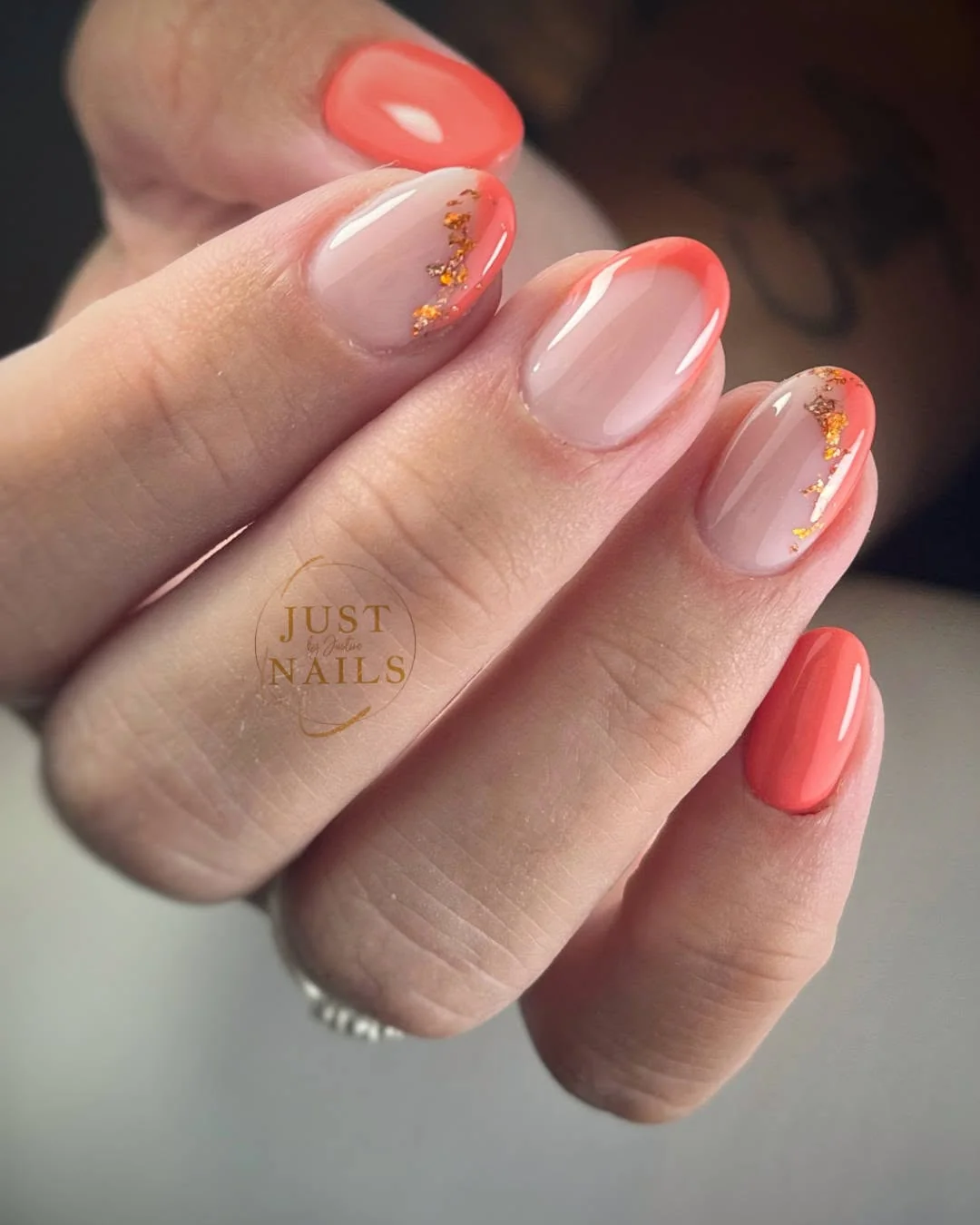 Soft peach and coral nails with French tips and gold foil