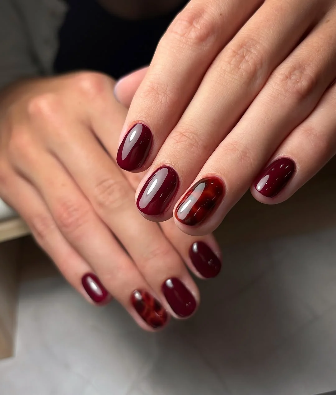 Burgundy almond nails with a tortoiseshell accent nail