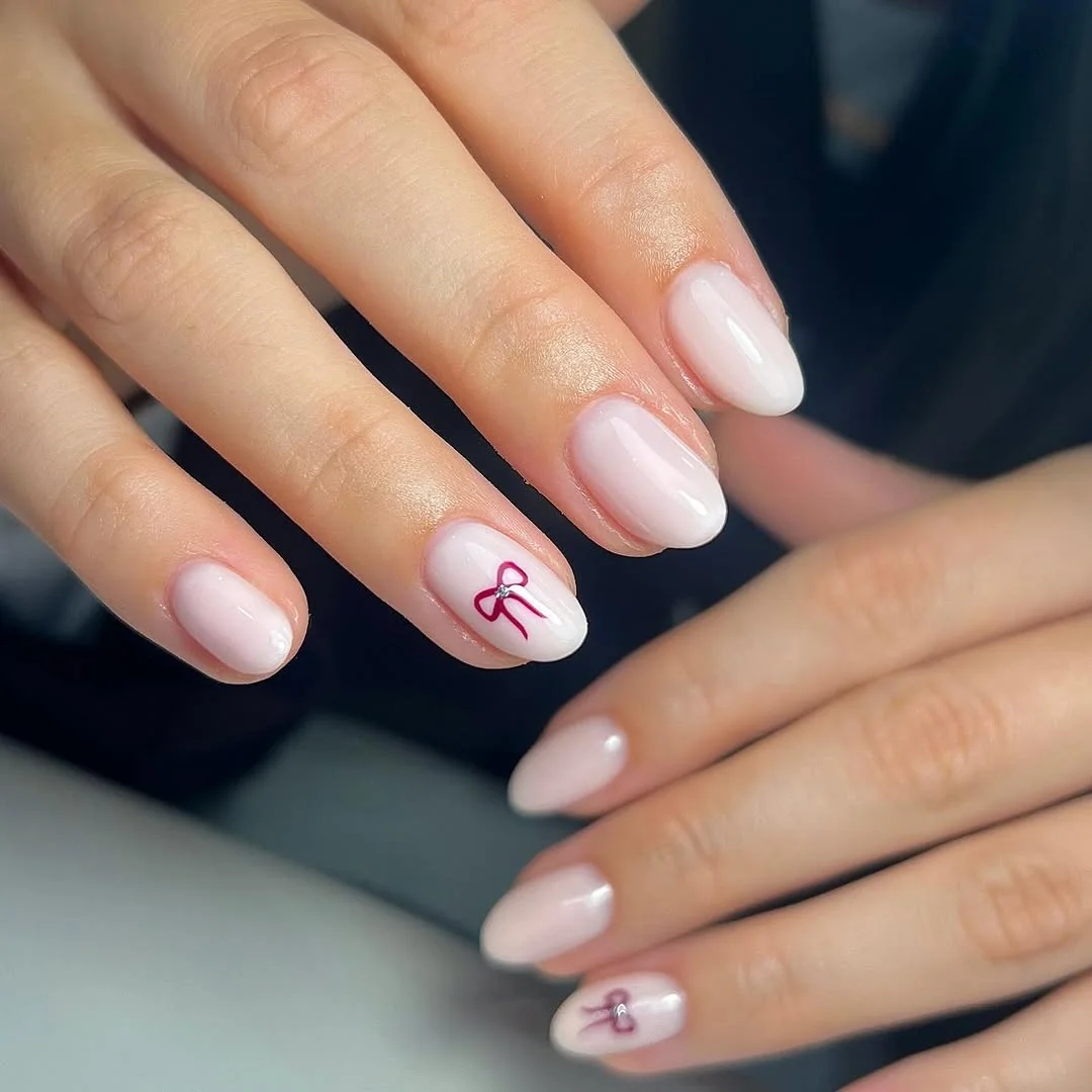 Milky white short nails with burgundy ribbon accents