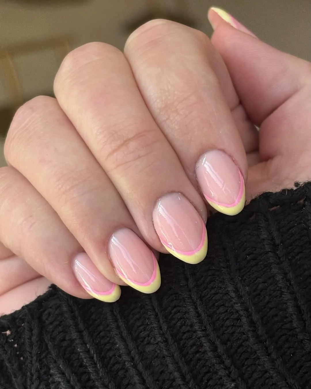 Sheer pink almond nails with soft yellow French tips