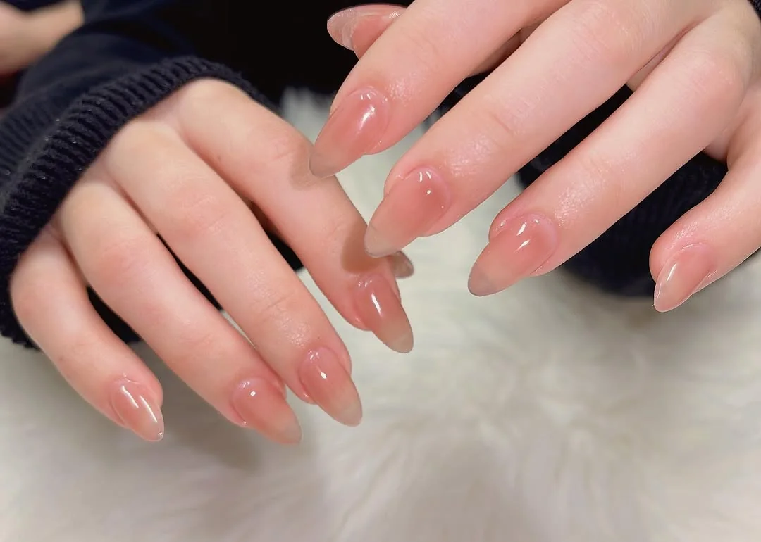 Sheer pink jelly almond nails with a glossy finish
