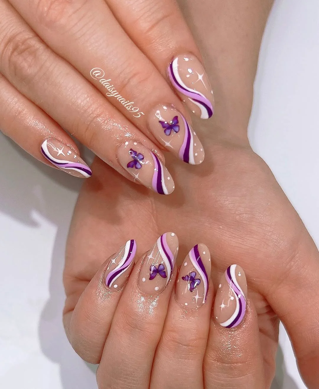 Clear nails with purple swirl lines and tiny purple butterflies