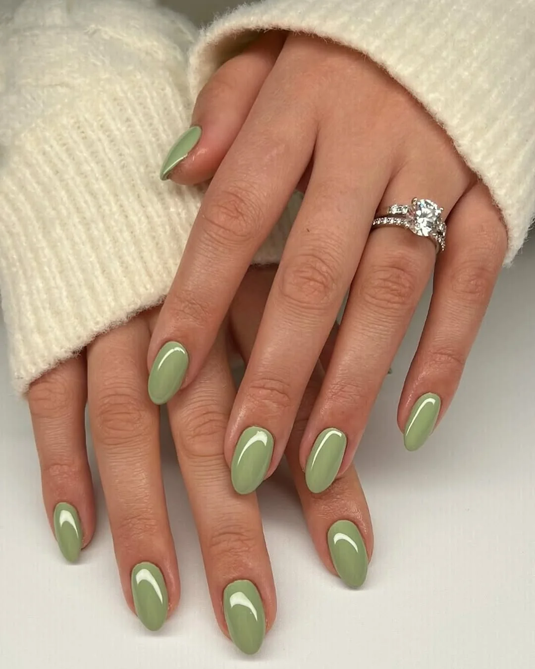 Sage green almond nails with a glossy finish