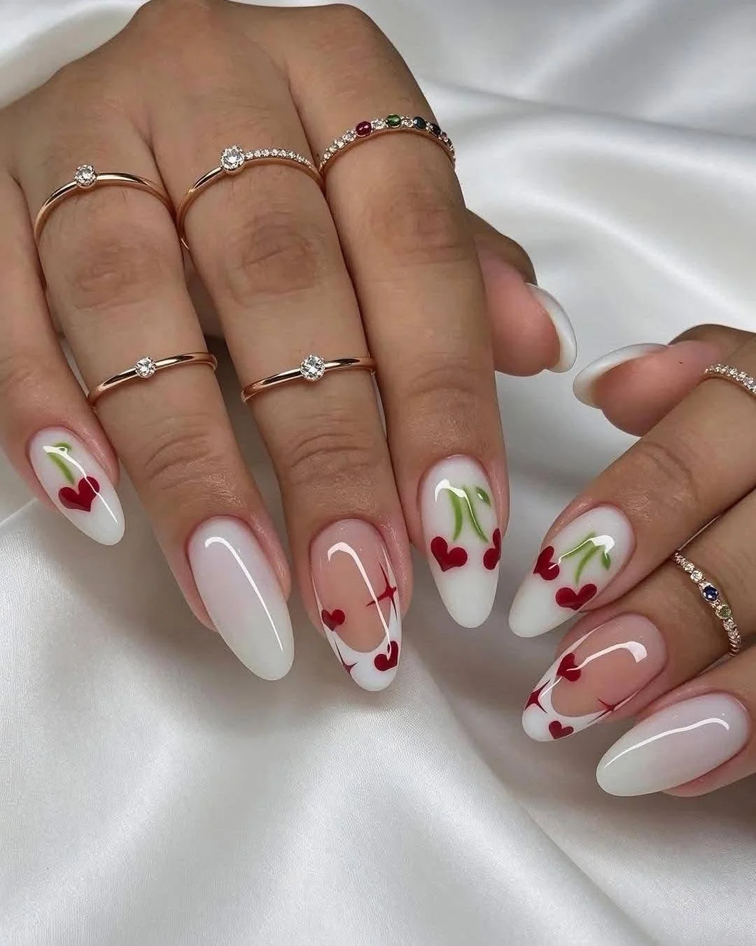 Milky white and nude almond nails with red cherry pairs