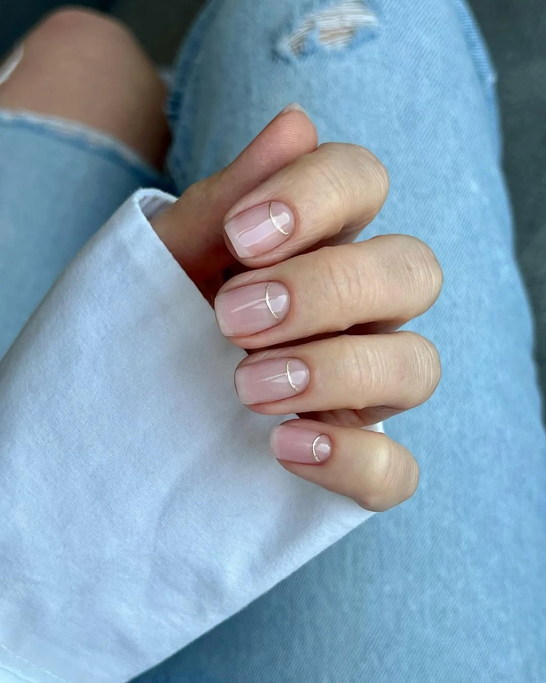 Short pink nails with negative-space half moon lines