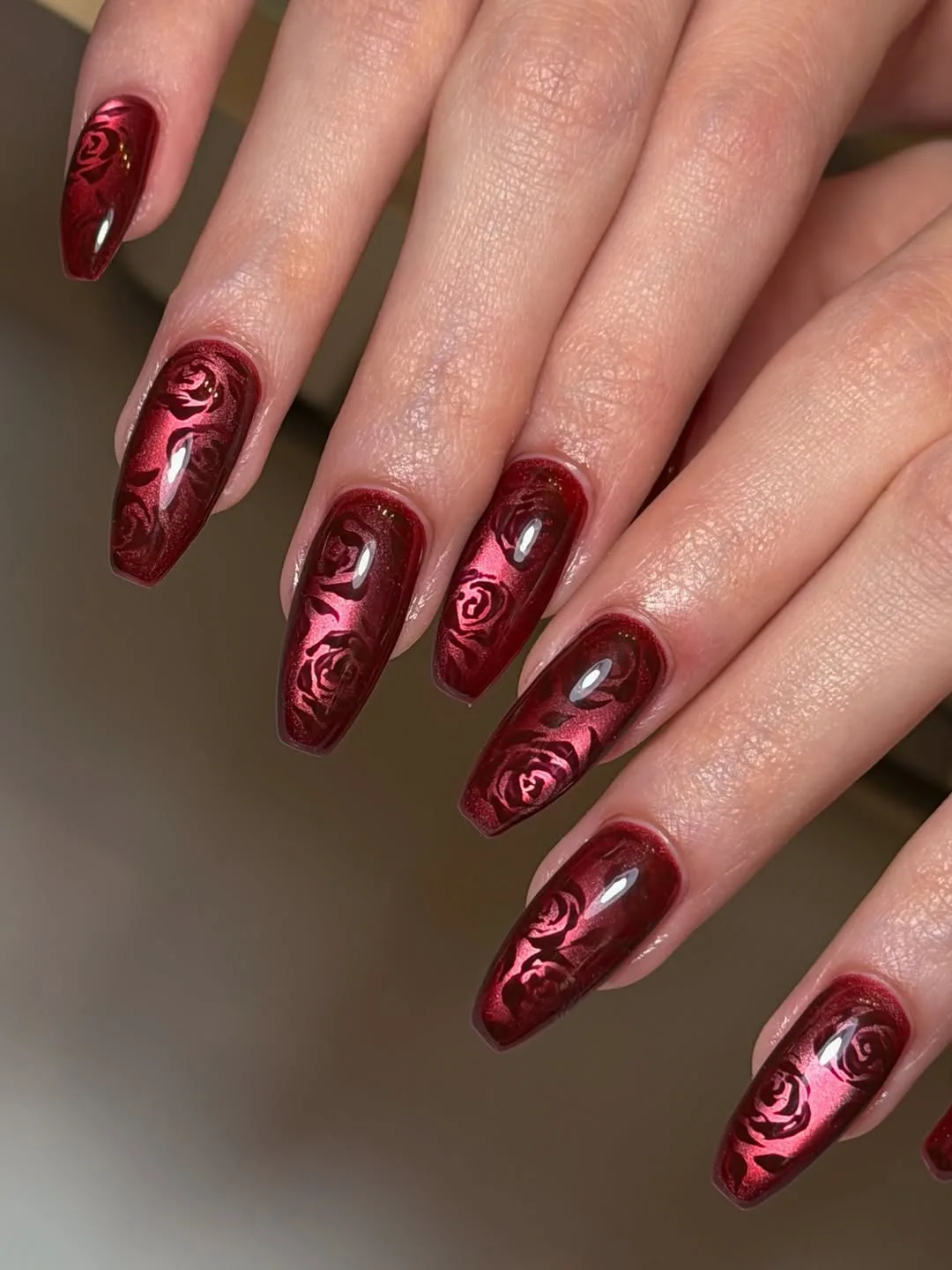 Cherry red almond nails with small glitter star accents