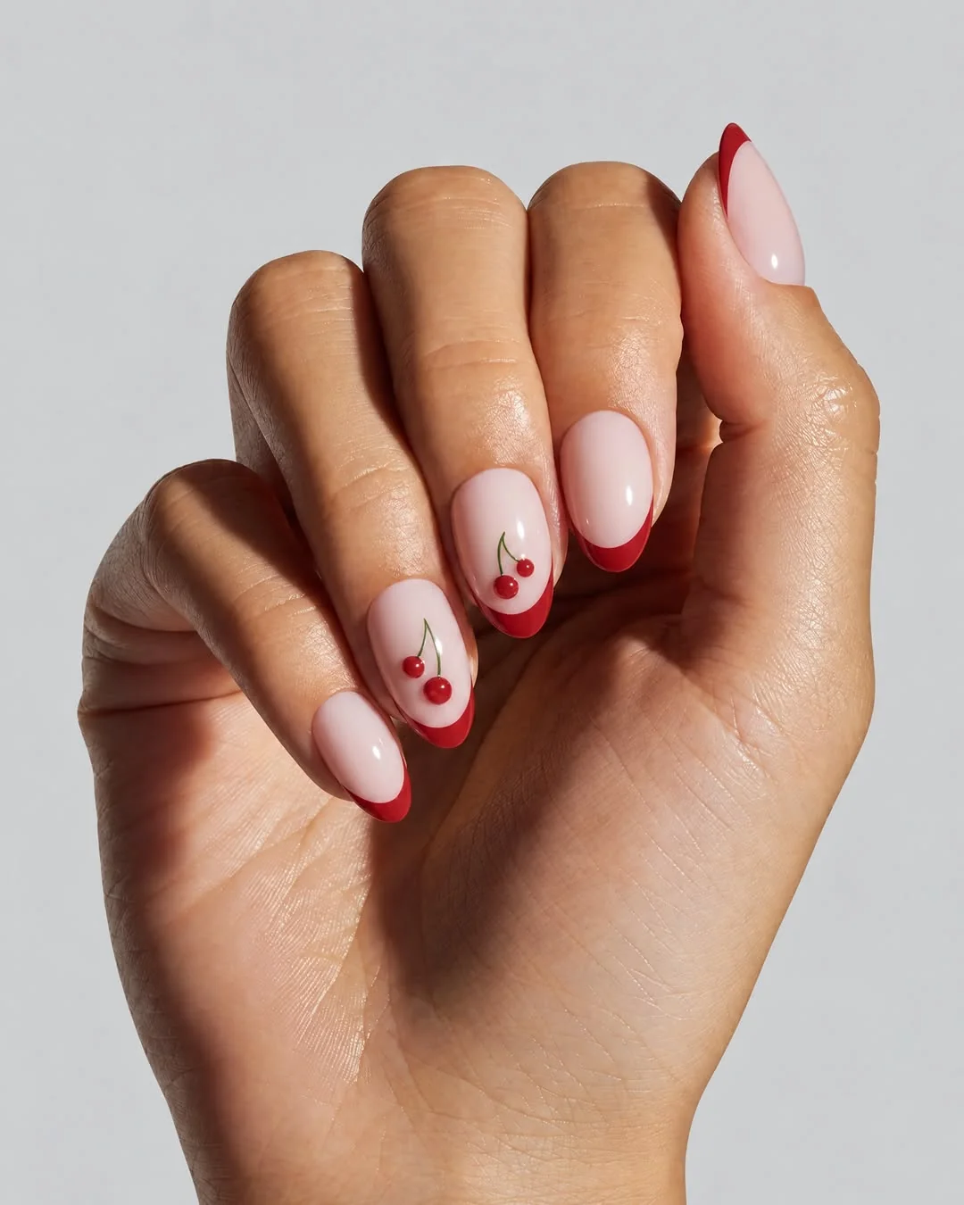 Short nude nails with red micro French tips and tiny cherries