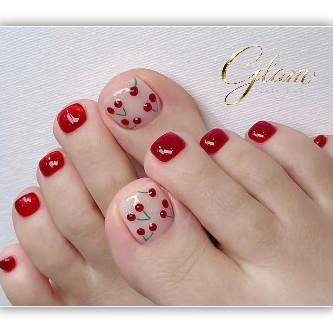Red pedicure with cherry art on the big toes