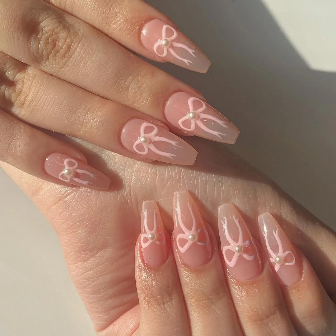 Sheer pink coffin nails with white fine-line bow outlines