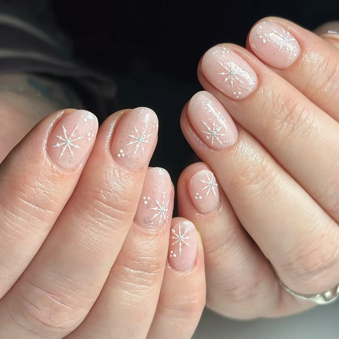 Sheer nude short nails with white snowflake art