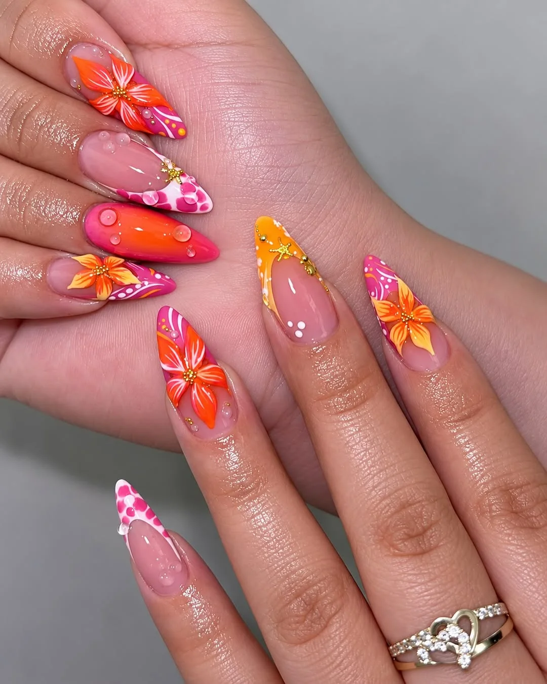 Orange and pink stiletto nails with tropical hibiscus flowers