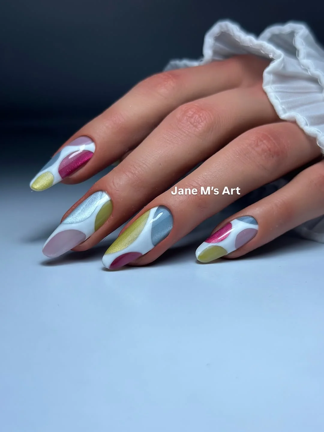 Almond nails with abstract pastel color-block art in blue, green and burgundy