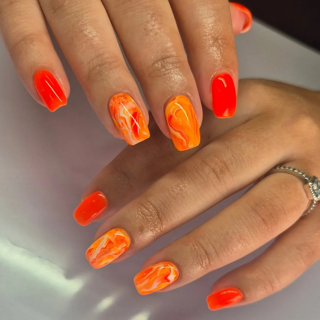 Bright orange marble swirl nails on short square tips