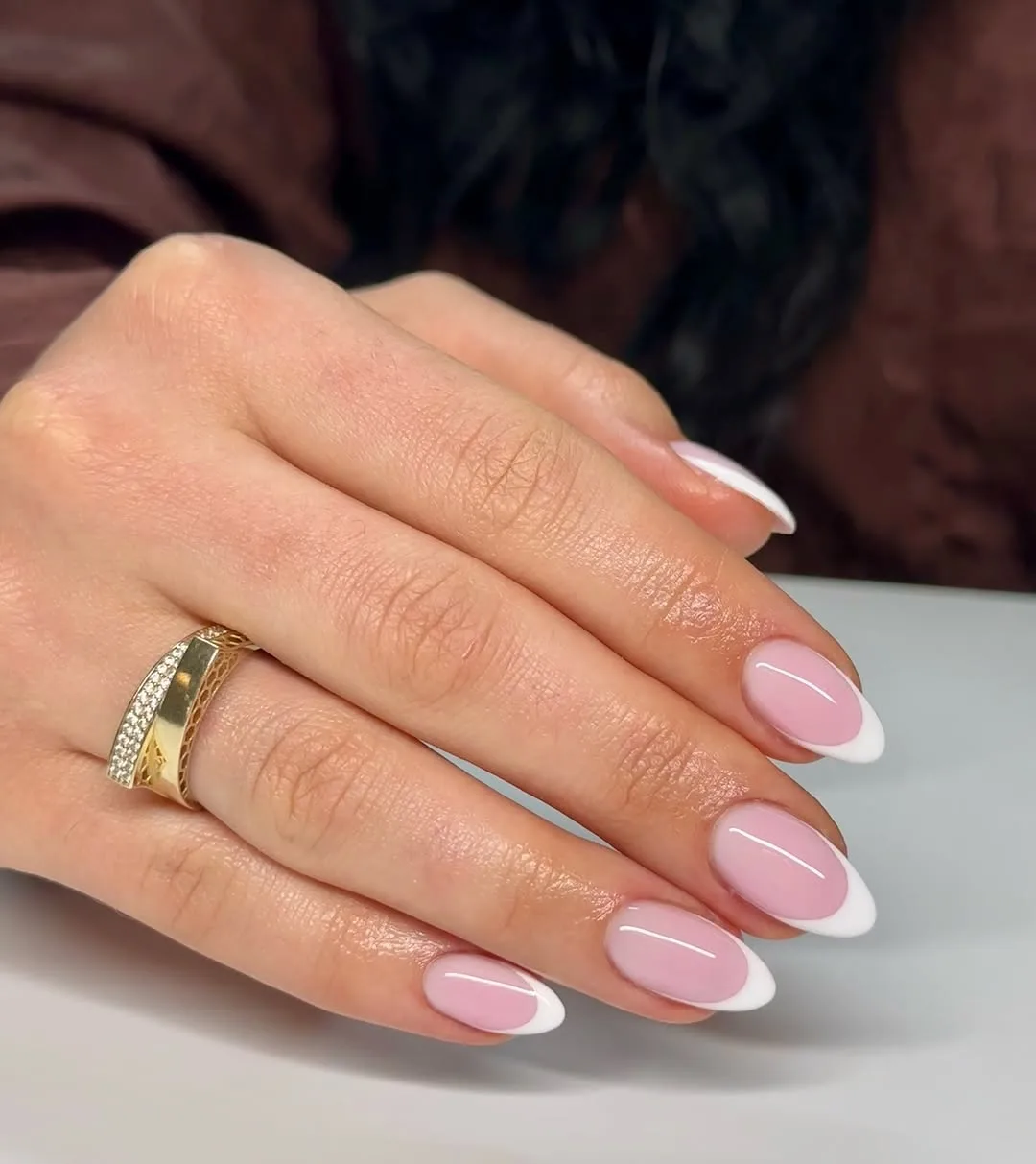 Short almond nails with a pink base and thin white French tips