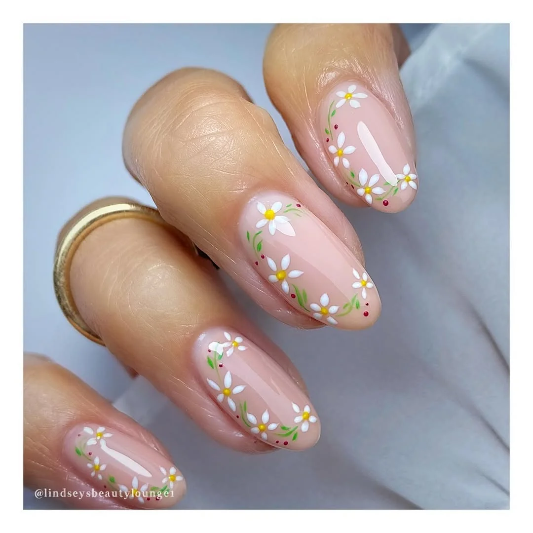 Sheer nude almond nails with a daisy chain vine along the nail