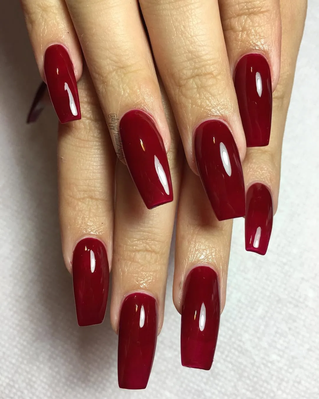 Long cherry red coffin nails with a glossy finish