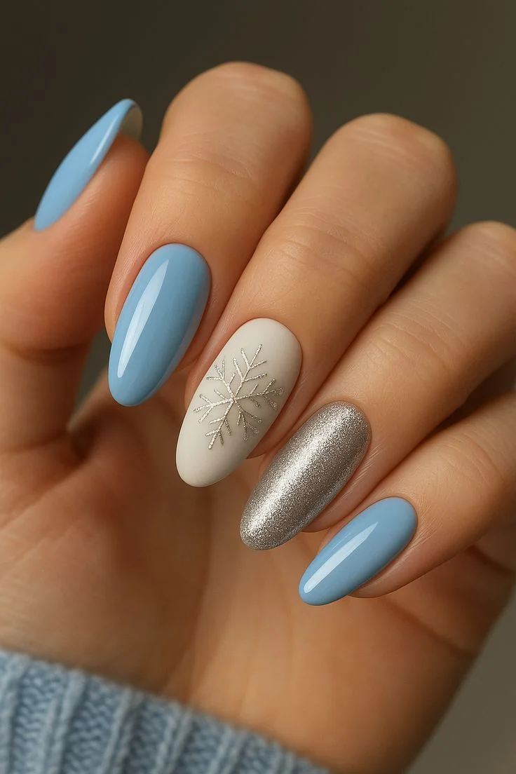 Blue gray almond nails with one cream snowflake accent nail and silver glitter