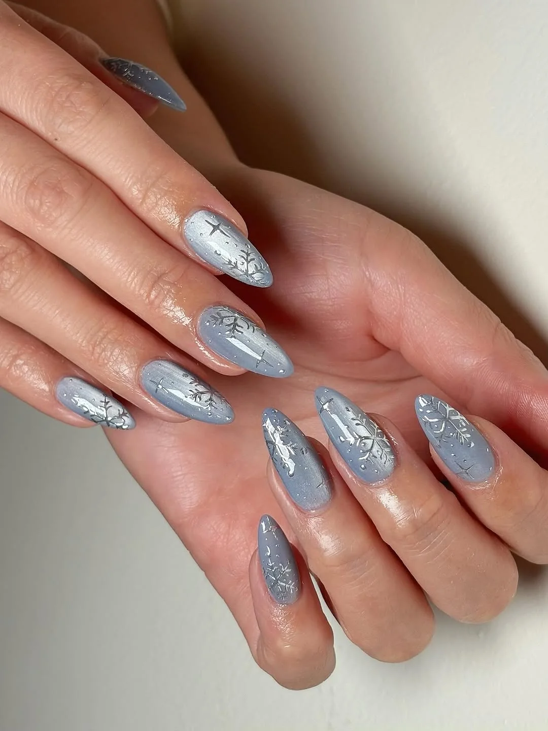 Gray blue almond nails with silver foil snowflake details