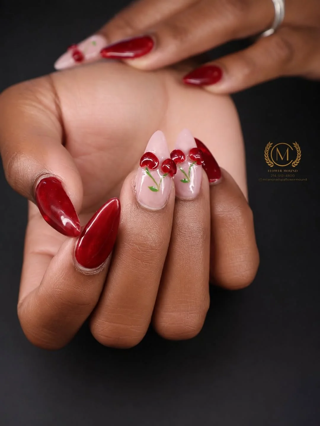 Glossy red nails with cherry art accent on nude nail