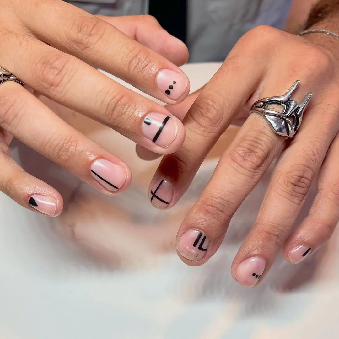 Short pink men's nails with minimal black dots and dashes