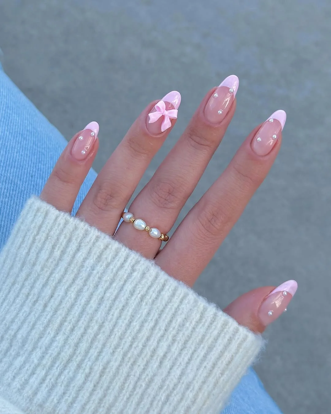 Short pink French tip nails with pink bow accent