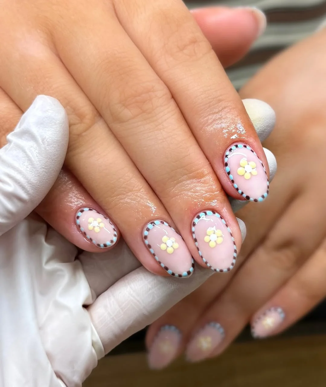 Pink almond nails with polka dot outlines and daisy art