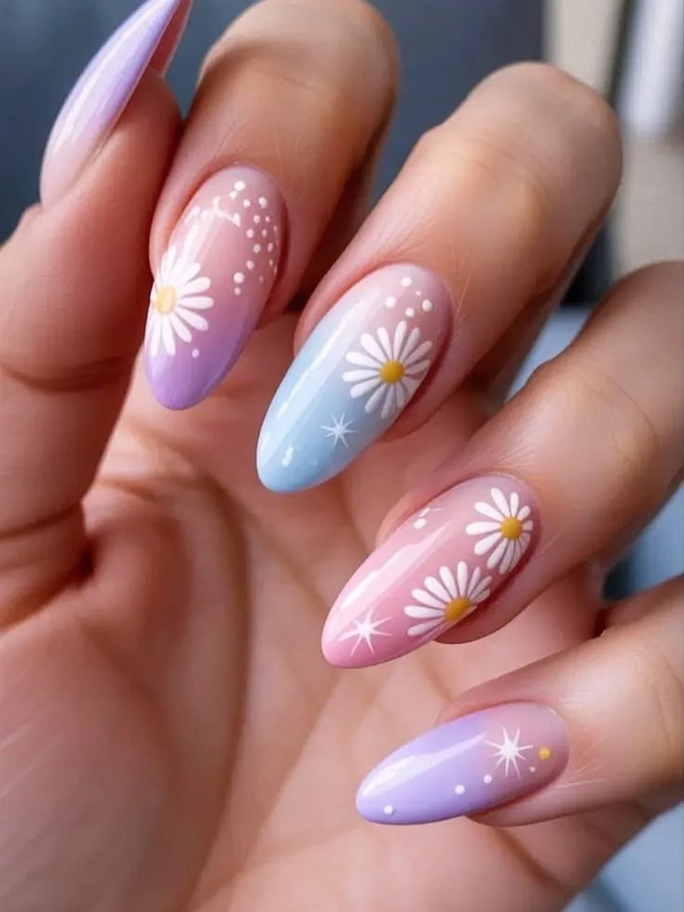 Pastel rainbow gradient almond nails with white daisies and sparkles