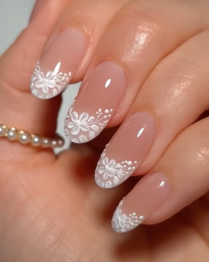 Sheer pink almond nails with white lace floral French tips