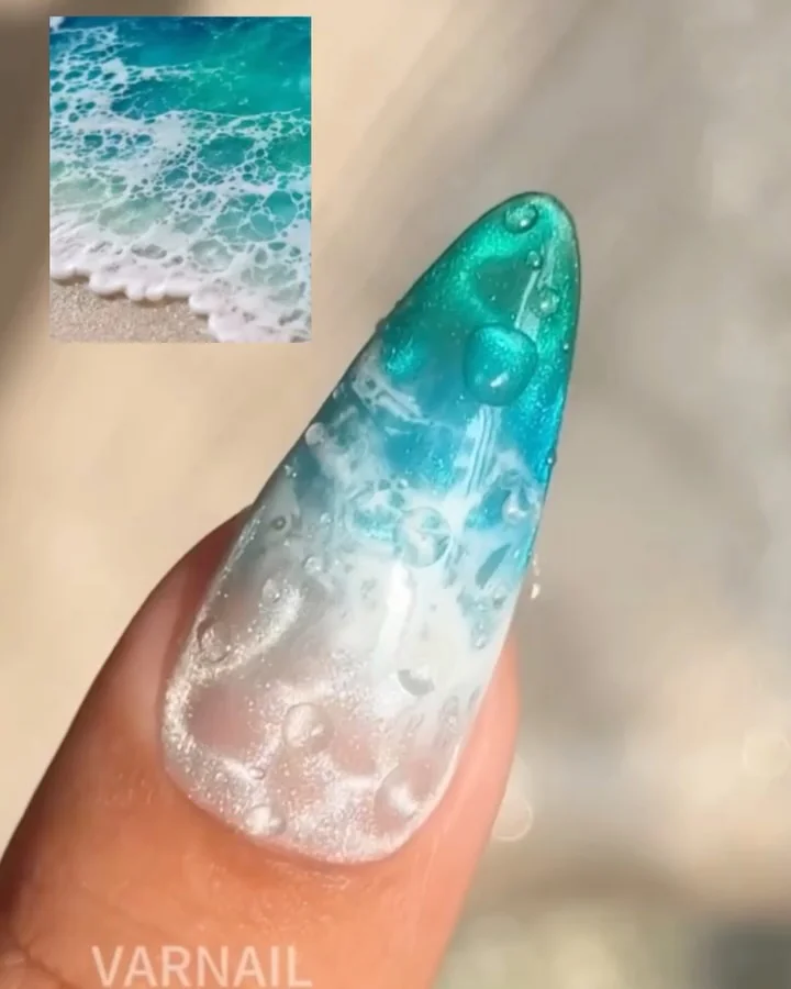 Stiletto nail with teal and white ocean wave resin art
