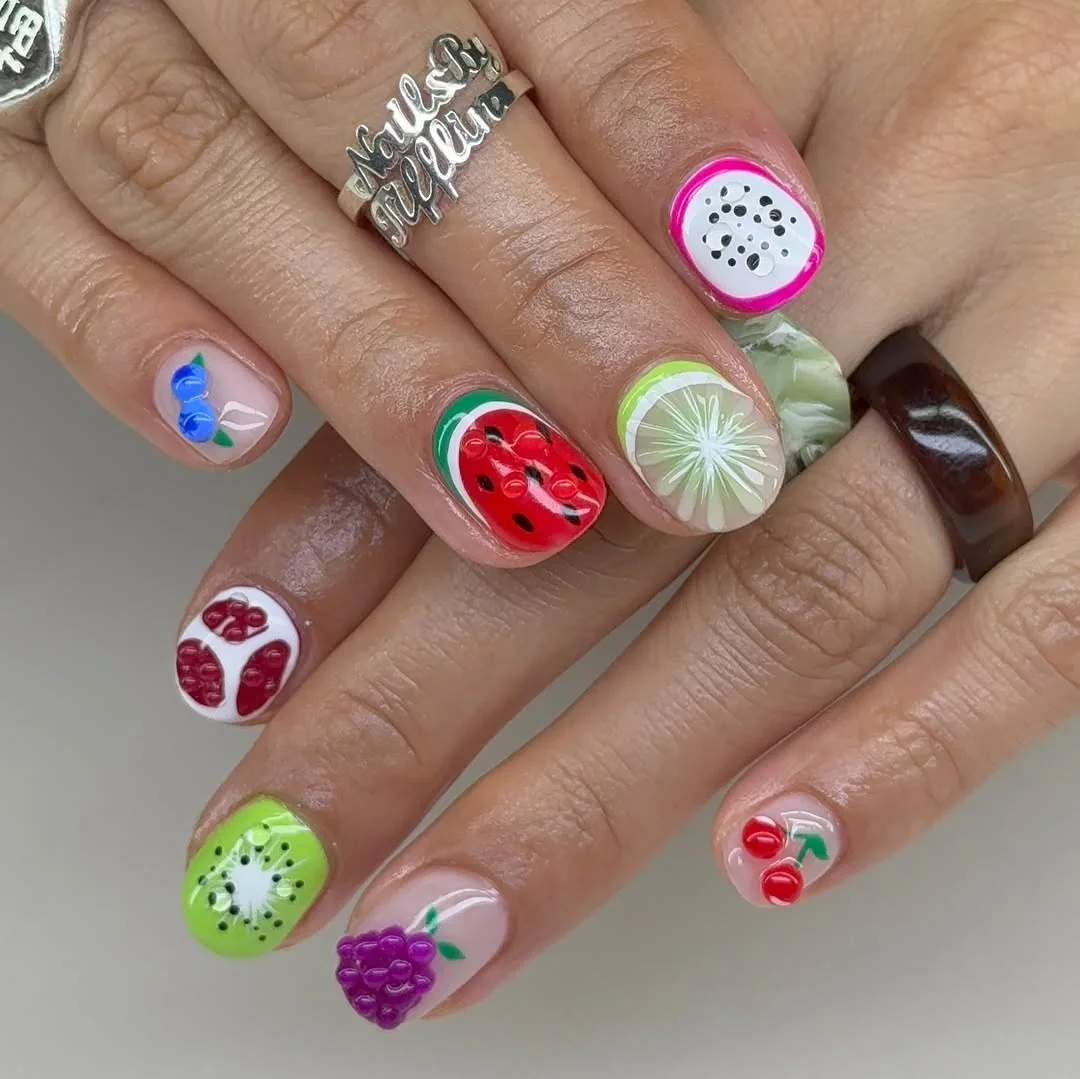 Short nails with bright summer fruit art including watermelon, kiwi and dragon fruit