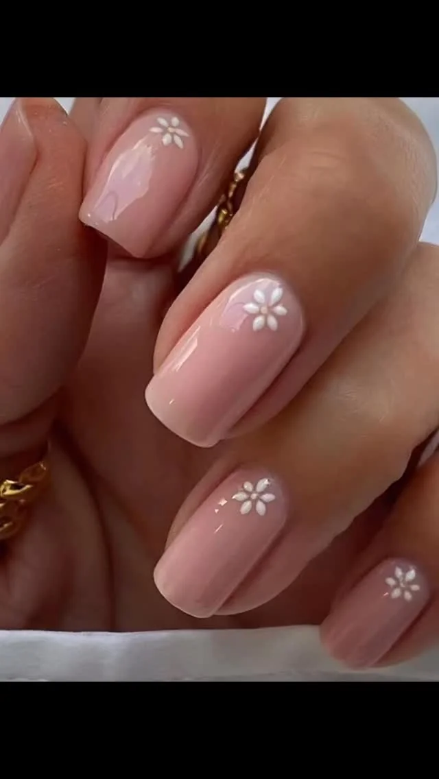 Short nude nails with a single tiny white daisy on each nail