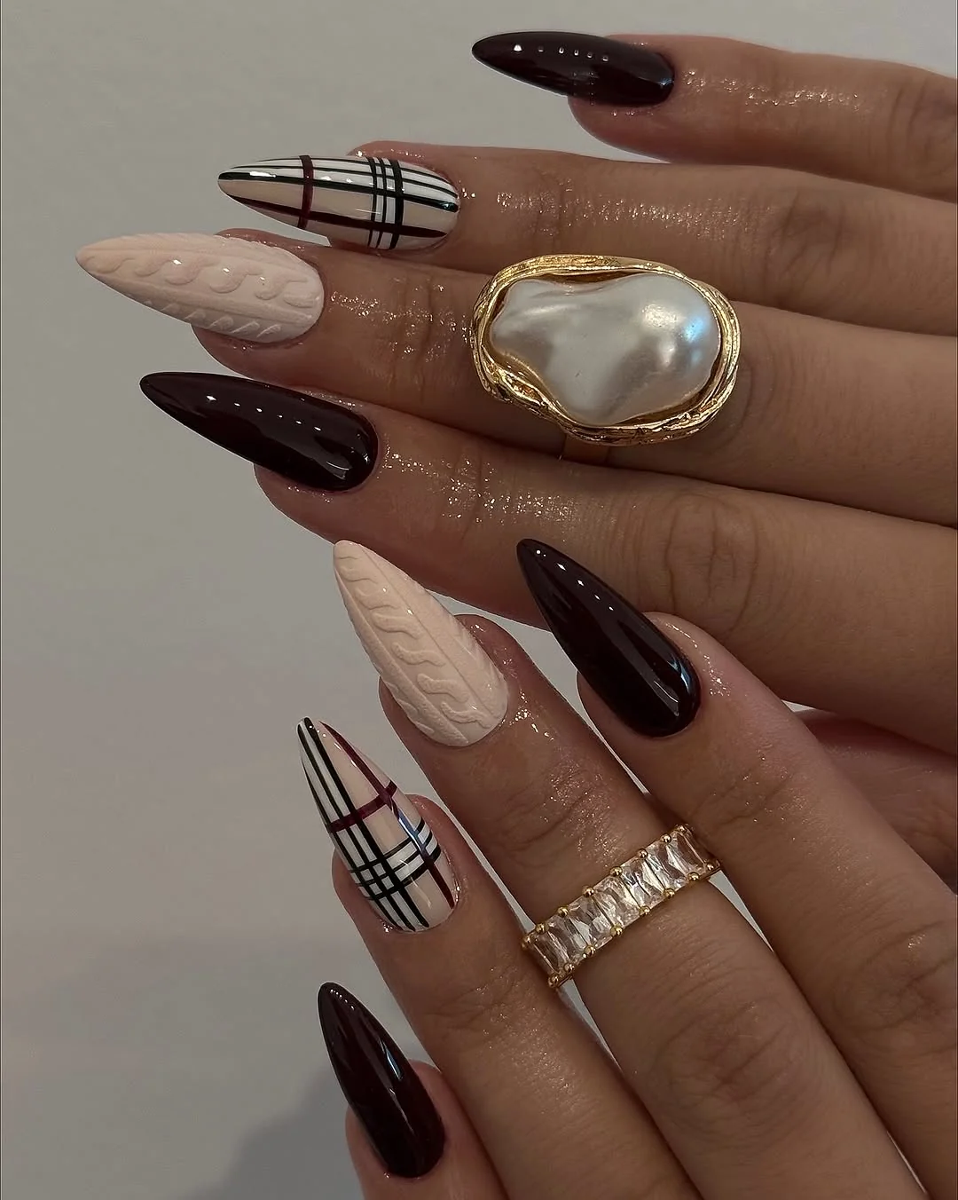 Almond nails with cream knit, plaid and dark brown accents
