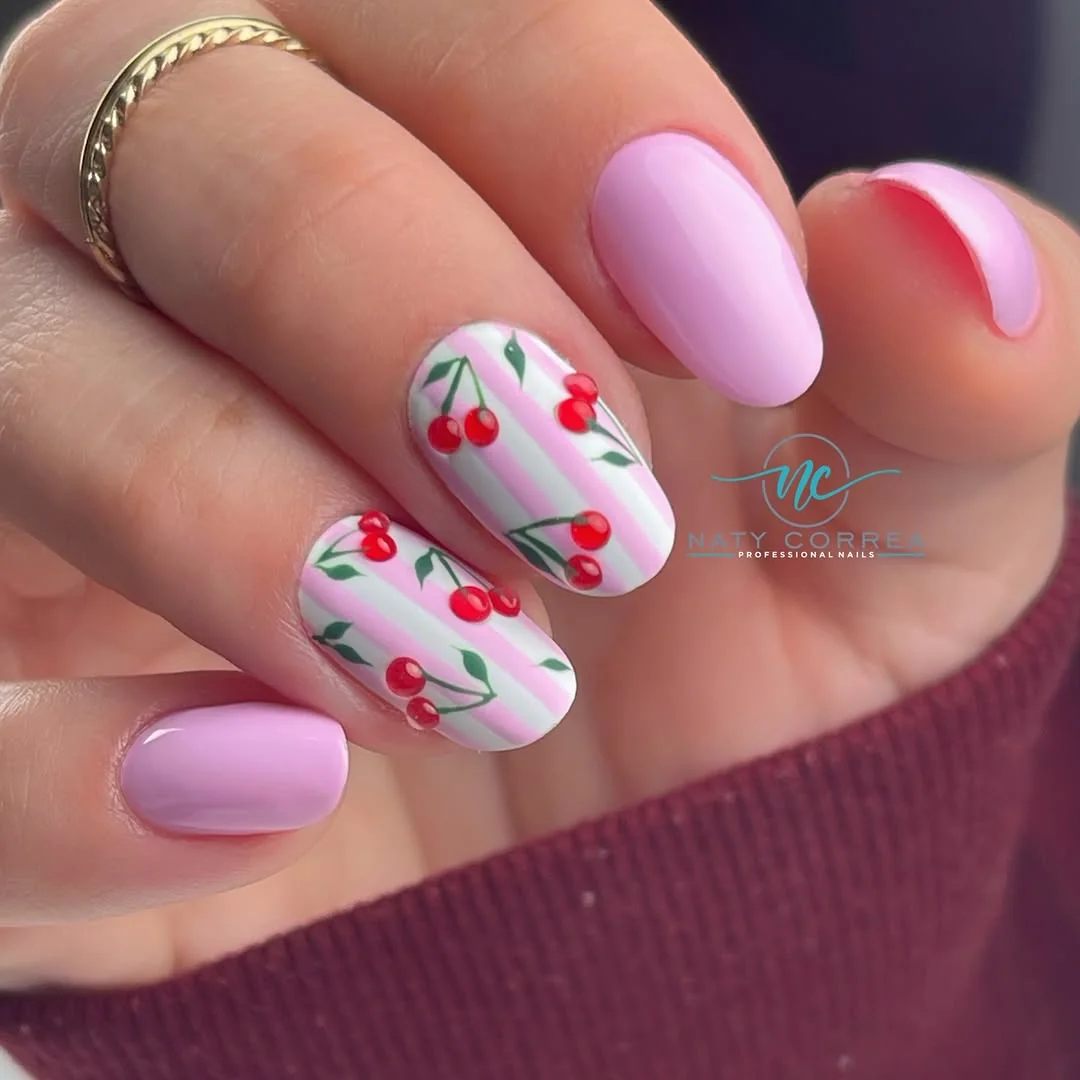 Pink and white striped nails with cherries and green leaves on short almond tips